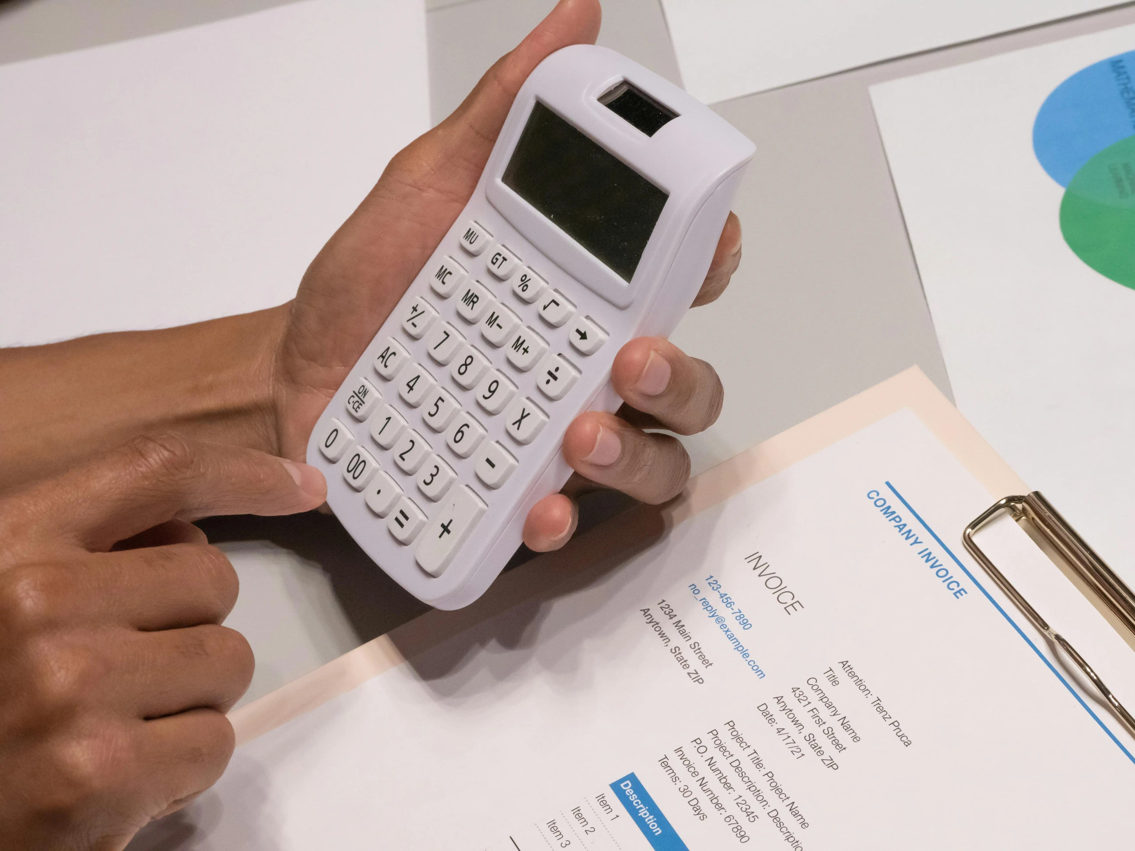 Hombre usando una calculadora para revisar sus facturas