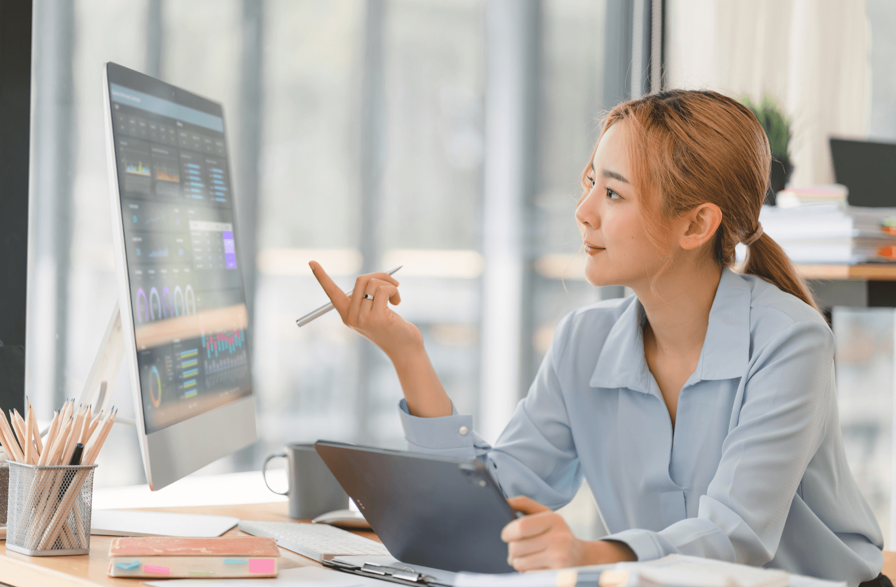 Una mujer analizando en su computadora los datos de sus clientes, pudiendo así tomar decisiones certeras sobre el manejo de sus relaciones con el cliente.